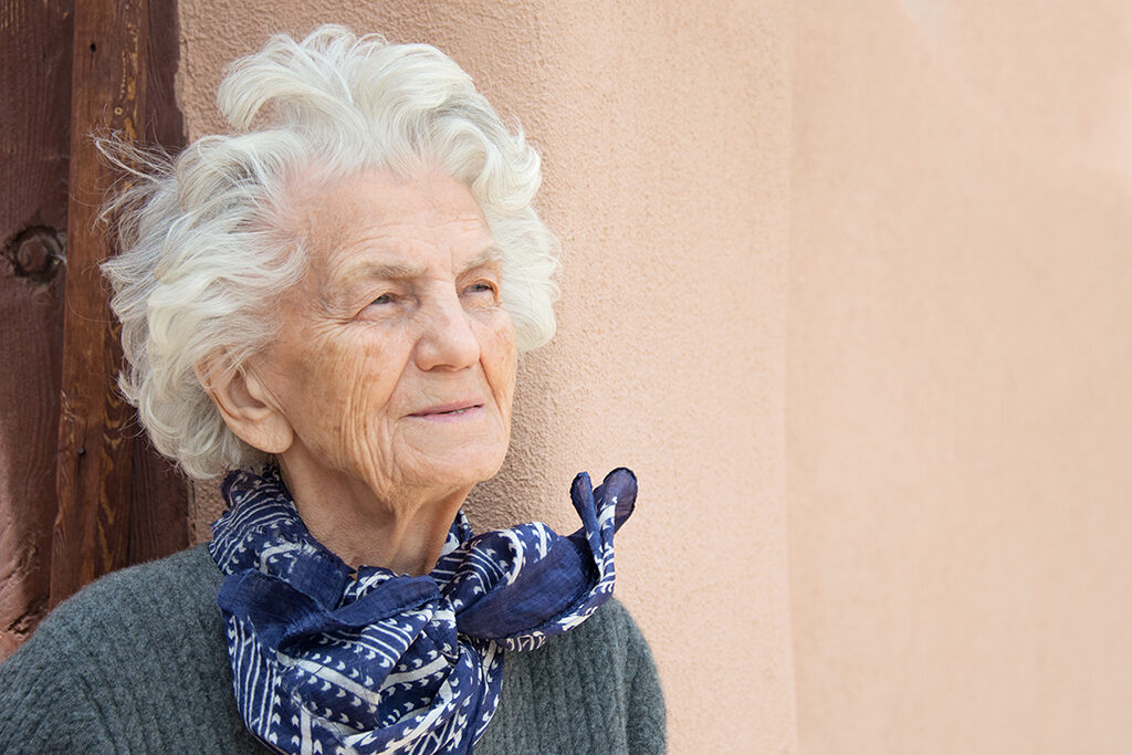 Eine Seniorin schaut in die Ferne.